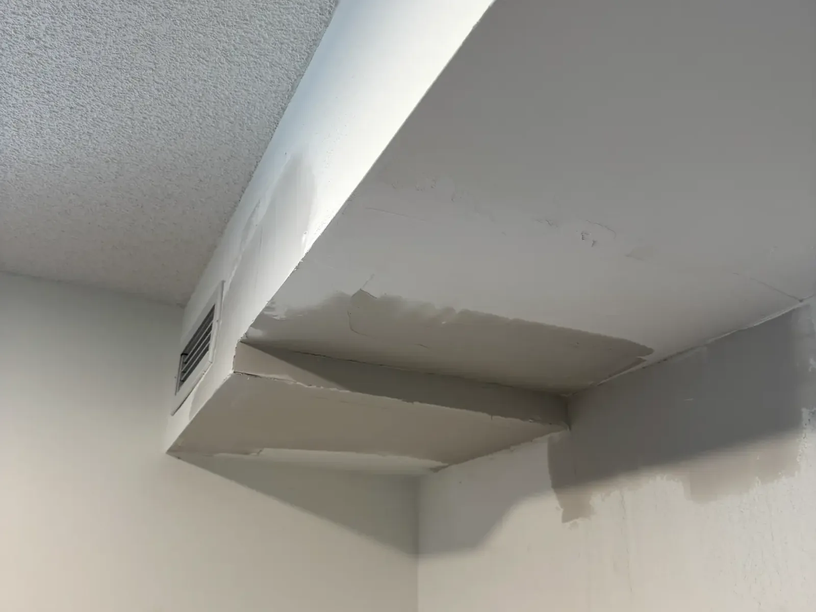 Unfinished patched drywall bulkhead before finishing