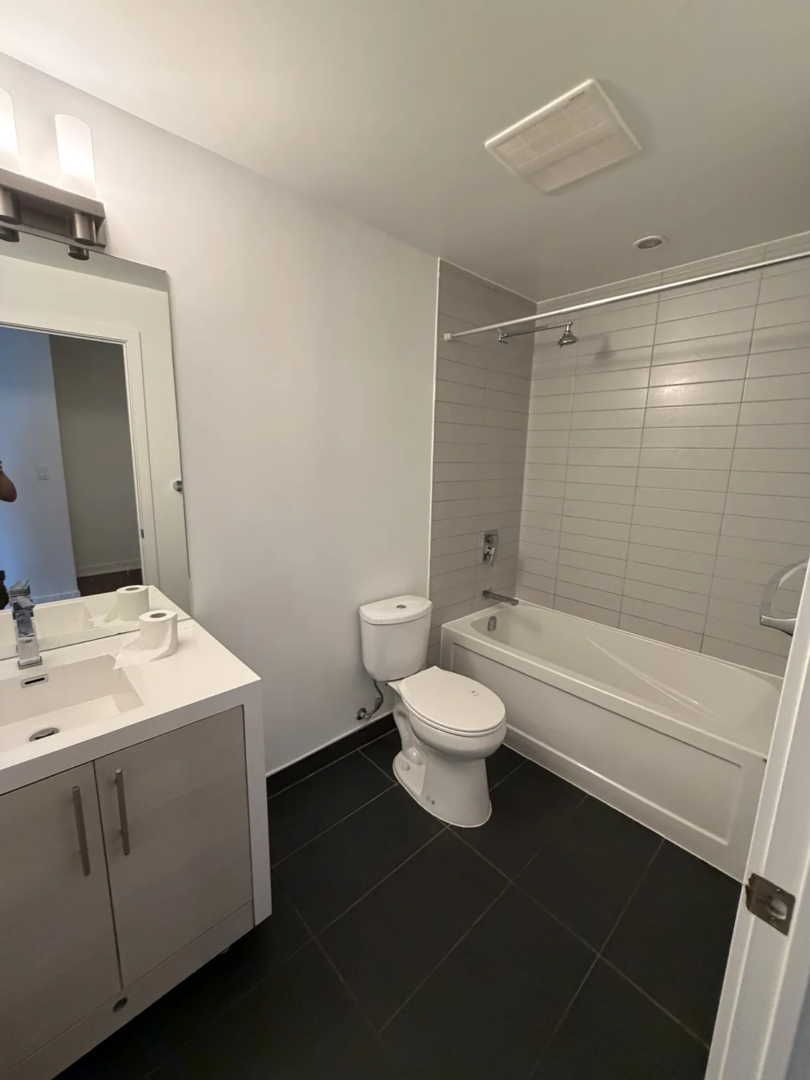 Clean repainted condo bathroom with vanity, tub and tiled floor